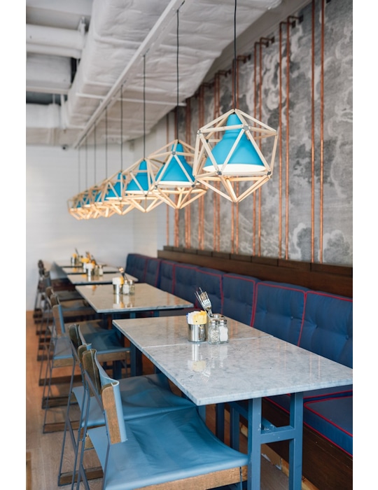 Classified Hong Kong is more than a dining experience; it's an architectural masterpiece that engages all the senses. Our inspiration drew from the café's coastal surroundings, translating into an architectural marvel that embraces marine-blue tiles, rustic timber flooring, and bespoke lobster-pot-inspired ceiling lights. Design by Studio Königshausen.